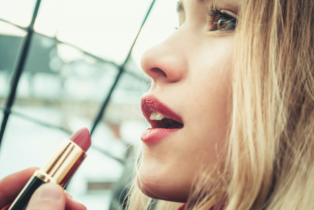 women-applying-lipstick-to-her-lips