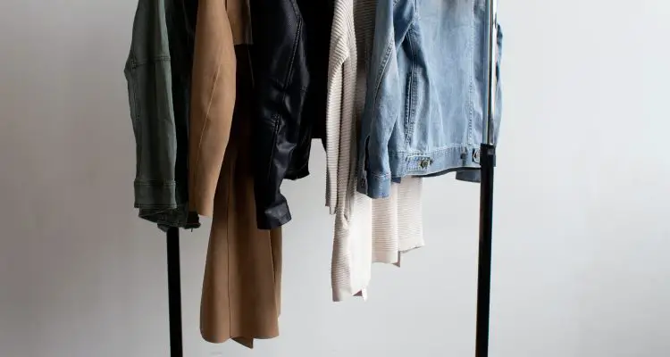 capsule wardrobe with few items of clothing hanging on the clothing rack