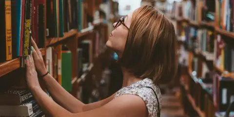 Student in the library trying to find a book