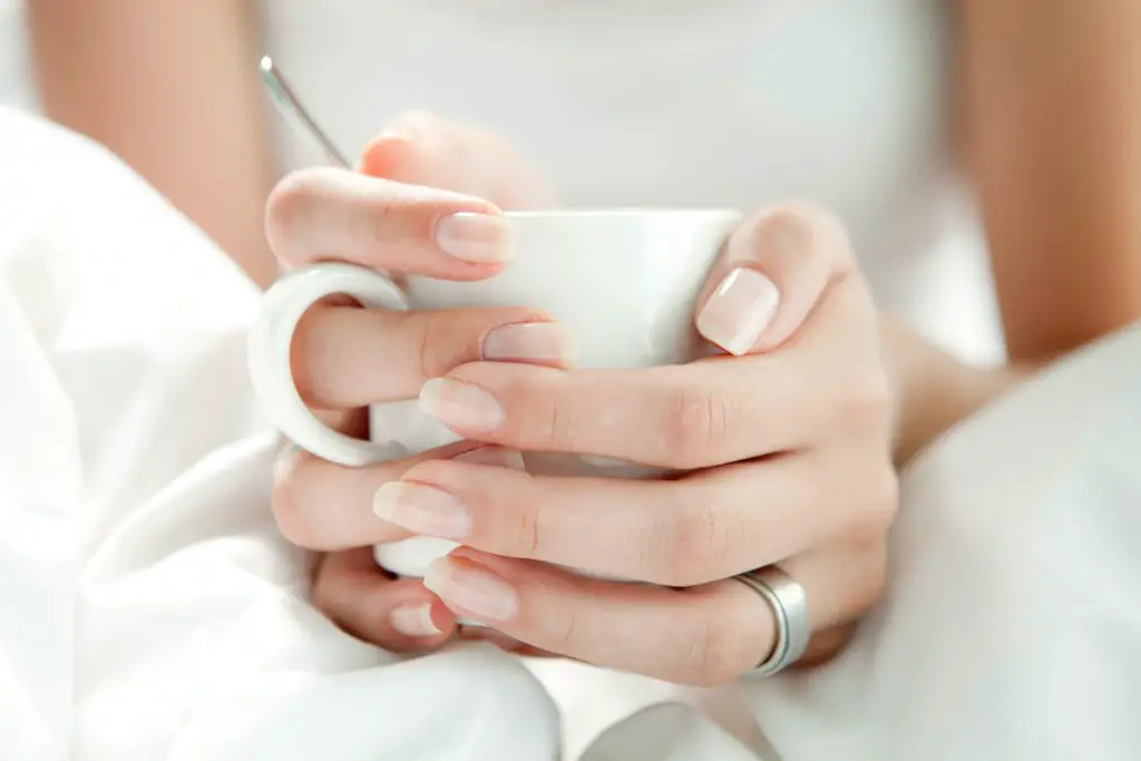 woman sitting in bed with morning coffee