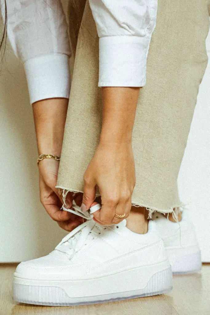 woman wearing baggy linen pants with white sneakers and white shirt