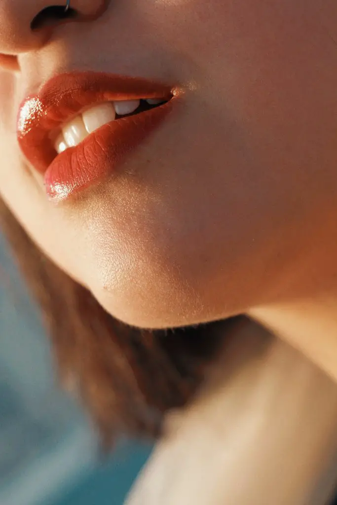 woman wearing pink lip balm with a nose ring
