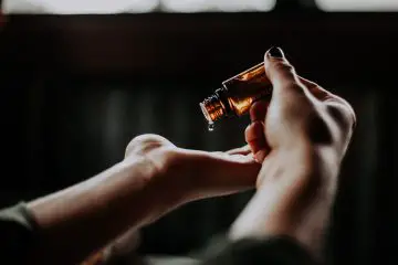 woman putting oil on her hands from a bottle