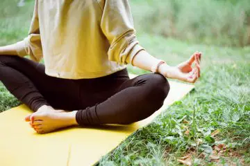 woman doing yoga on a yellow yoga mat