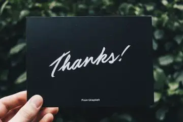 woman holding a card saying thanks