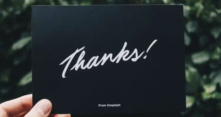 woman holding a card saying thanks