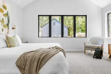bedroom with double bed and white covers with a big window